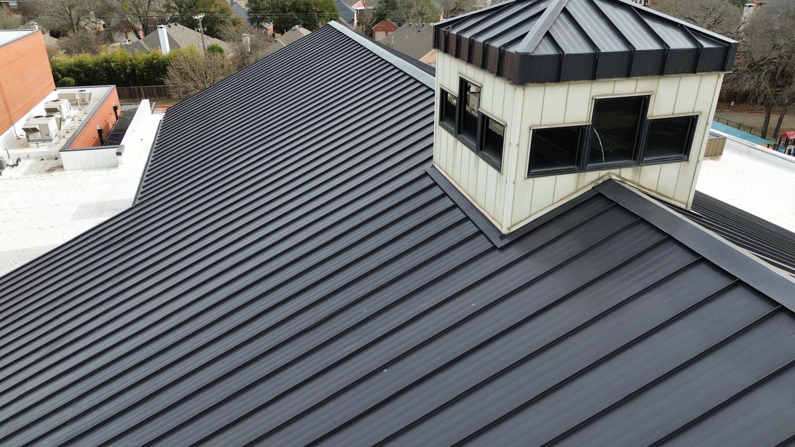 Angled view of a dark standing-seam metal roof and cupola from Alliance Roofing’s project photos